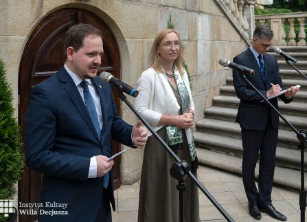 fotografia. art piknik w willi decjusza. konsul węgier Tibor Gerencsér przemawia u stóp schodów przed willą, obok dyrektorka instytutu kultury willa decjusza dominika kasprowicz.